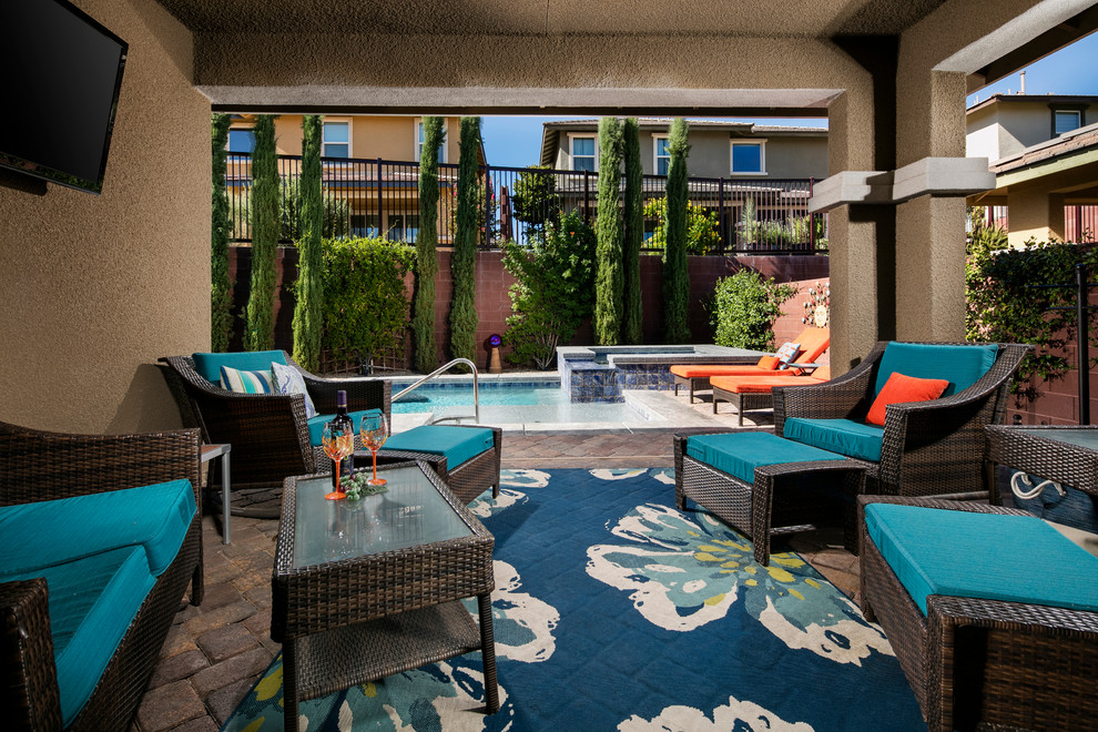 Photo of a mid-sized transitional backyard patio in Las Vegas with brick pavers and a roof extension.