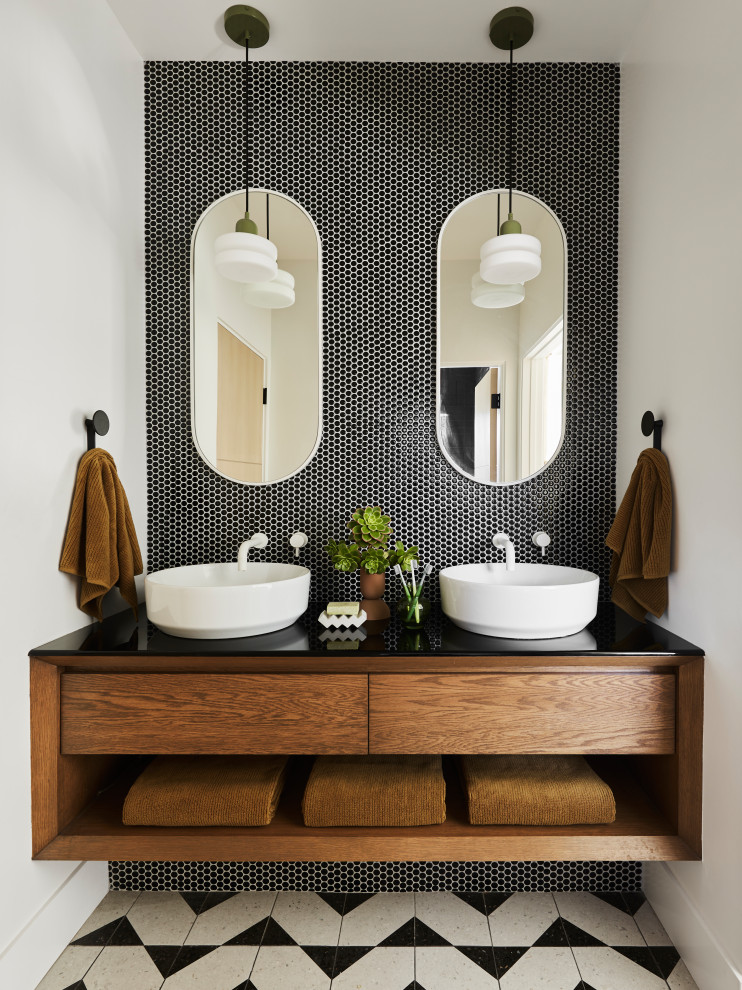 Réalisation d'une salle d'eau design en bois brun avec un placard à porte plane, un carrelage noir et blanc, mosaïque, une vasque, un plan de toilette en quartz modifié, un plan de toilette noir, meuble double vasque et meuble-lavabo suspendu.