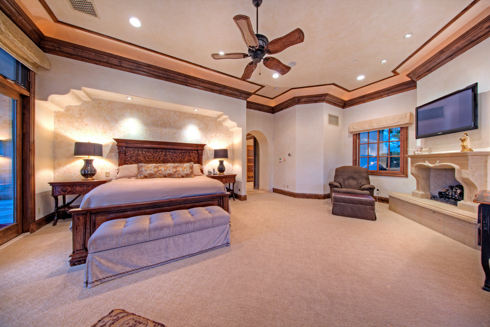 Expansive mediterranean master bedroom in Phoenix with carpet and a standard fireplace.