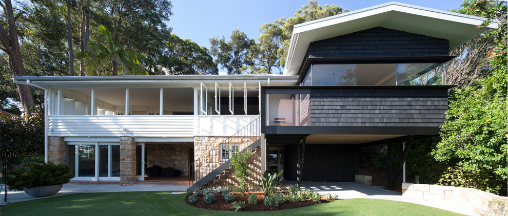 This is an example of a contemporary two-storey black exterior in Central Coast with wood siding and a gable roof.
