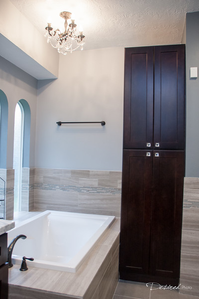This is an example of a large transitional master bathroom in Houston with an undermount sink, shaker cabinets, dark wood cabinets, quartzite benchtops, a drop-in tub, a corner shower, a two-piece toilet, gray tile, porcelain tile, grey walls and porcelain floors.
