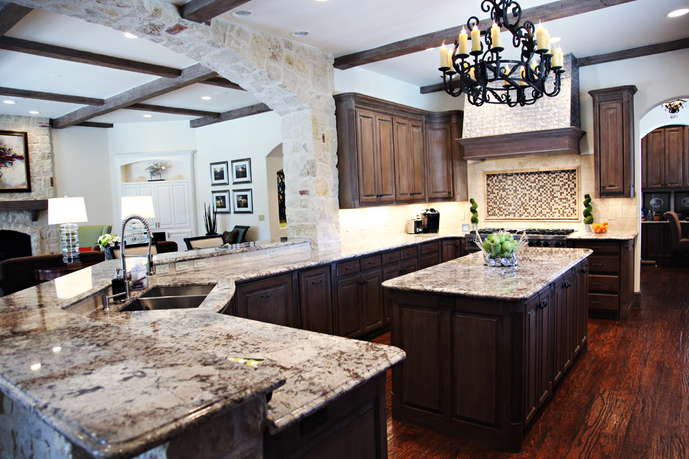 Traditional kitchen in Dallas with raised-panel cabinets, dark wood cabinets and granite benchtops.