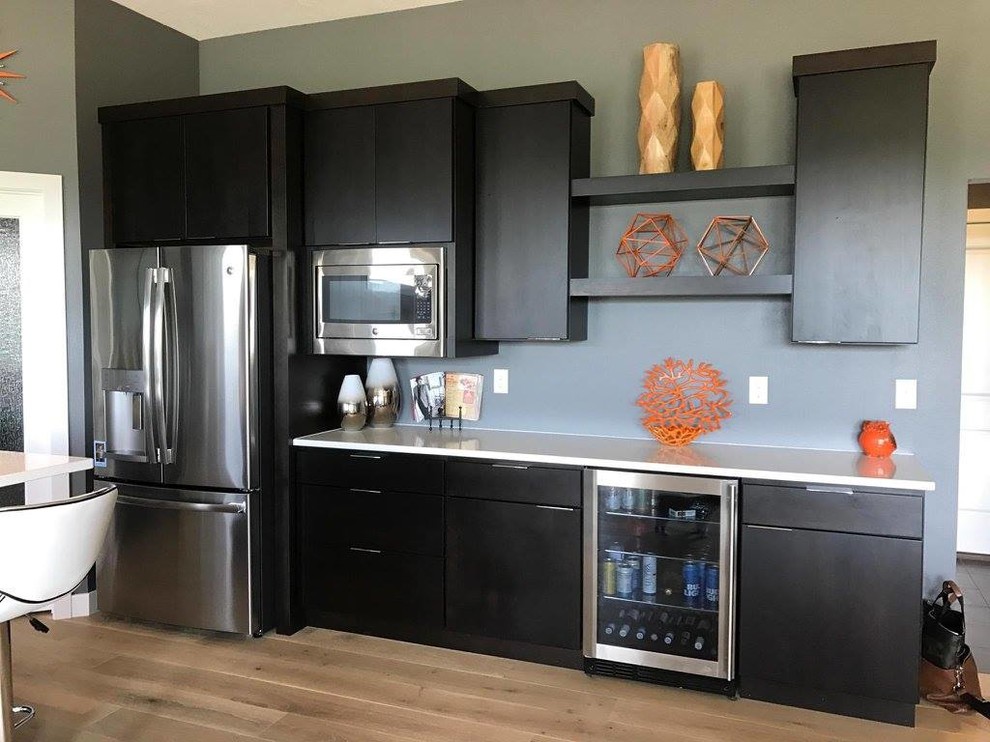 Inspiration for a small contemporary kitchen remodel with an undermount sink, flat-panel cabinets, dark wood cabinets, stainless steel appliances and an island