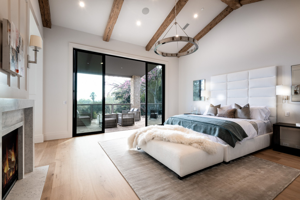 Inspiration for a large country master bedroom in Los Angeles with white walls, light hardwood flooring, a two-sided fireplace, a stacked stone fireplace surround, beige floors, exposed beams and panelled walls.