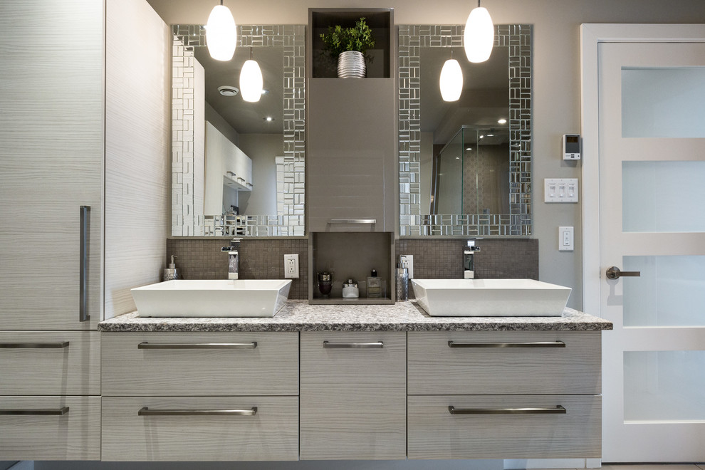 Photo of a mid-sized contemporary 3/4 bathroom in Montreal with flat-panel cabinets, grey cabinets, a corner tub, an open shower, a one-piece toilet, gray tile, white tile, stone tile, beige walls, dark hardwood floors, a pedestal sink, granite benchtops, beige floor and an open shower.
