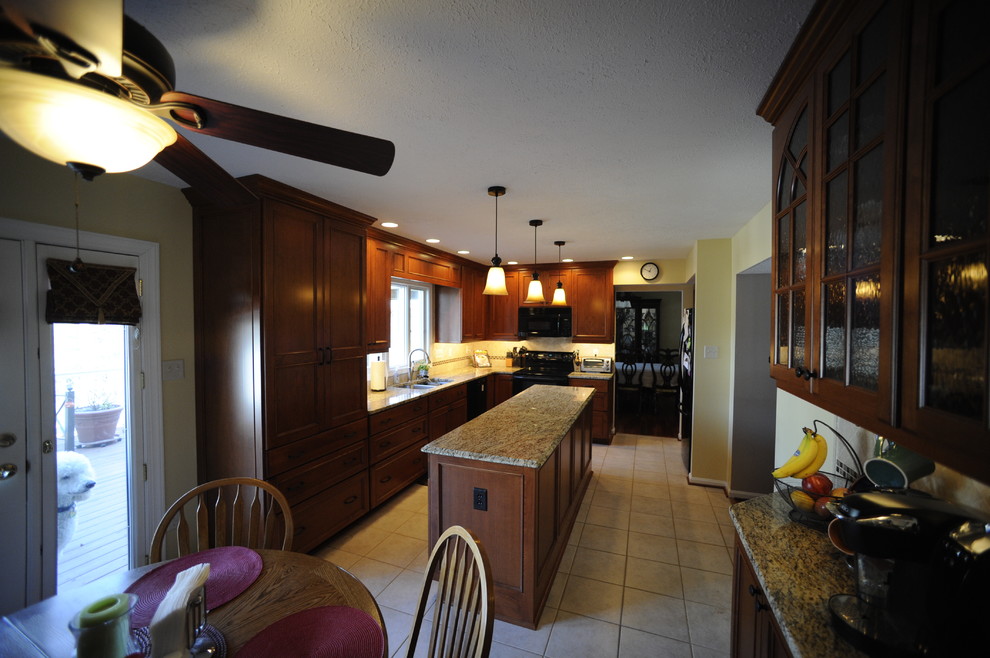 Inspiration for a mid-sized transitional u-shaped limestone floor enclosed kitchen remodel in Baltimore with an undermount sink, beaded inset cabinets, dark wood cabinets, granite countertops, beige backsplash, stone tile backsplash, stainless steel appliances and a peninsula