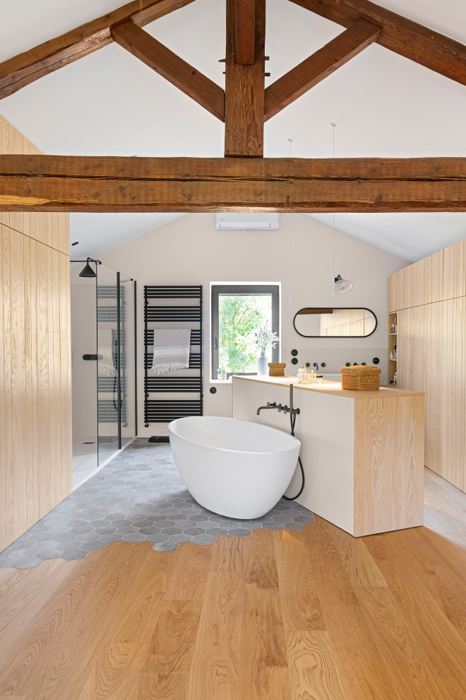 This is an example of a large eclectic 3/4 bathroom in Lyon with beaded inset cabinets, a wall-mount toilet, white walls, light hardwood floors, a trough sink, wood benchtops, a single vanity, a built-in vanity and recessed.