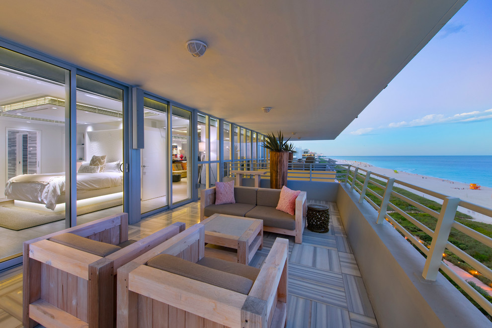 Photo of a large modern backyard deck in Miami with a roof extension.