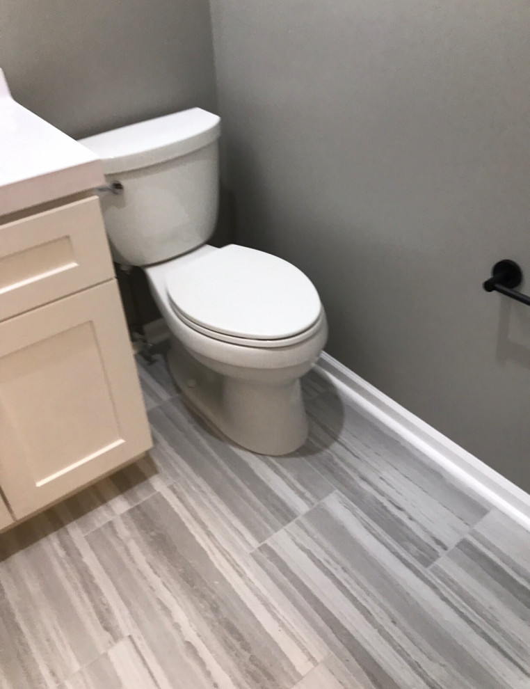Exemple d'un petit WC et toilettes moderne avec un placard à porte shaker, des portes de placard blanches, WC séparés, un mur gris, un sol en vinyl, un lavabo intégré, un sol gris, un plan de toilette blanc et meuble-lavabo encastré.
