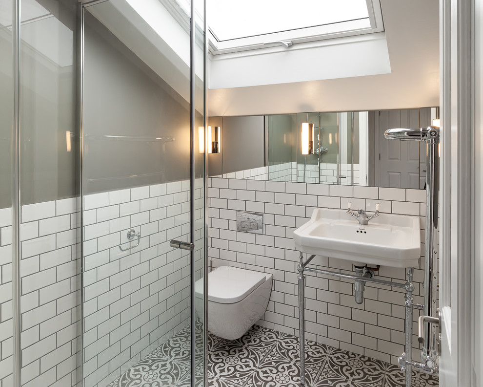 Photo of a small traditional master bathroom in London with glass-front cabinets, a corner shower, a wall-mount toilet, white tile, ceramic tile, grey walls, ceramic floors, a pedestal sink, multi-coloured floor and a hinged shower door.
