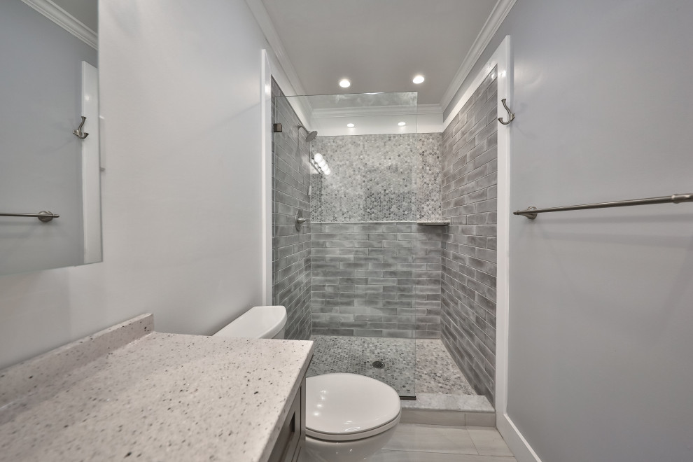 Mid-sized contemporary master bathroom in Philadelphia with flat-panel cabinets, grey cabinets, an open shower, a one-piece toilet, gray tile, ceramic tile, blue walls, porcelain floors, a drop-in sink, engineered quartz benchtops, beige floor, an open shower, grey benchtops, a single vanity and a freestanding vanity.