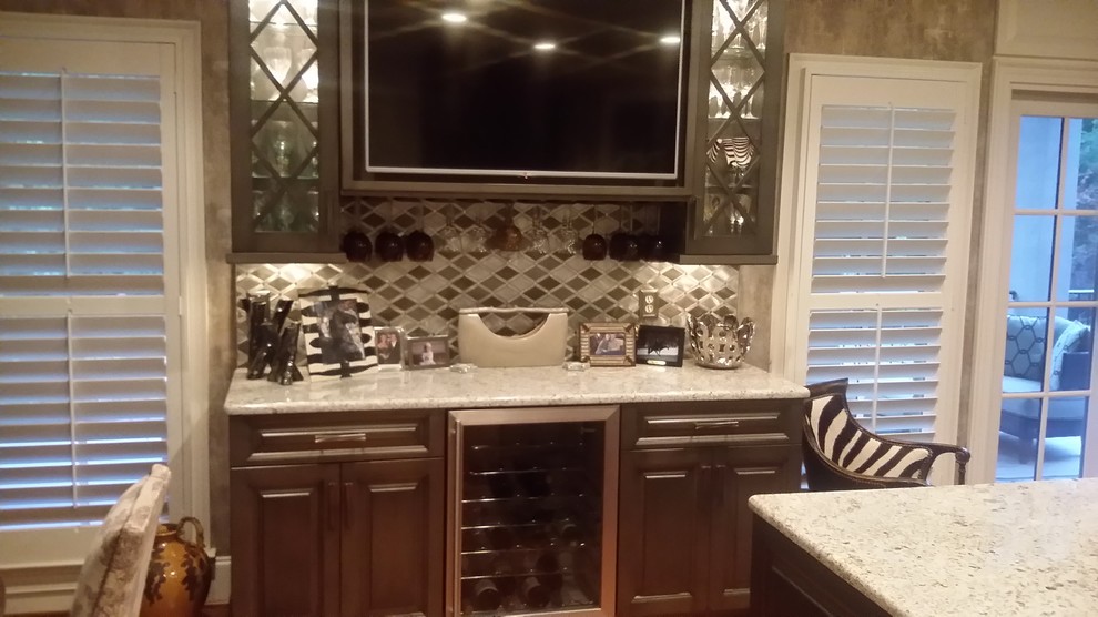 Large transitional l-shaped medium tone wood floor eat-in kitchen photo with raised-panel cabinets, dark wood cabinets, granite countertops, beige backsplash, ceramic backsplash, stainless steel appliances and an island