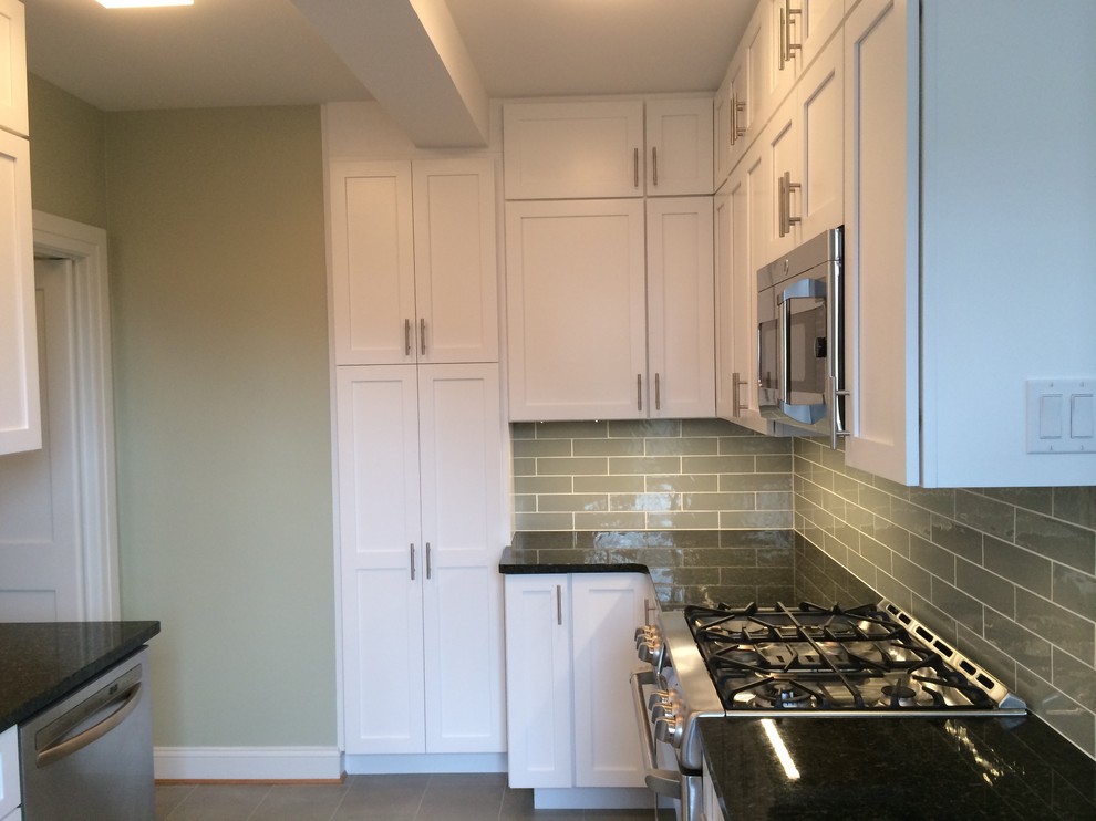 Mid-sized transitional u-shaped porcelain tile enclosed kitchen photo in Orange County with an undermount sink, shaker cabinets, white cabinets, granite countertops, gray backsplash, ceramic backsplash, stainless steel appliances and no island