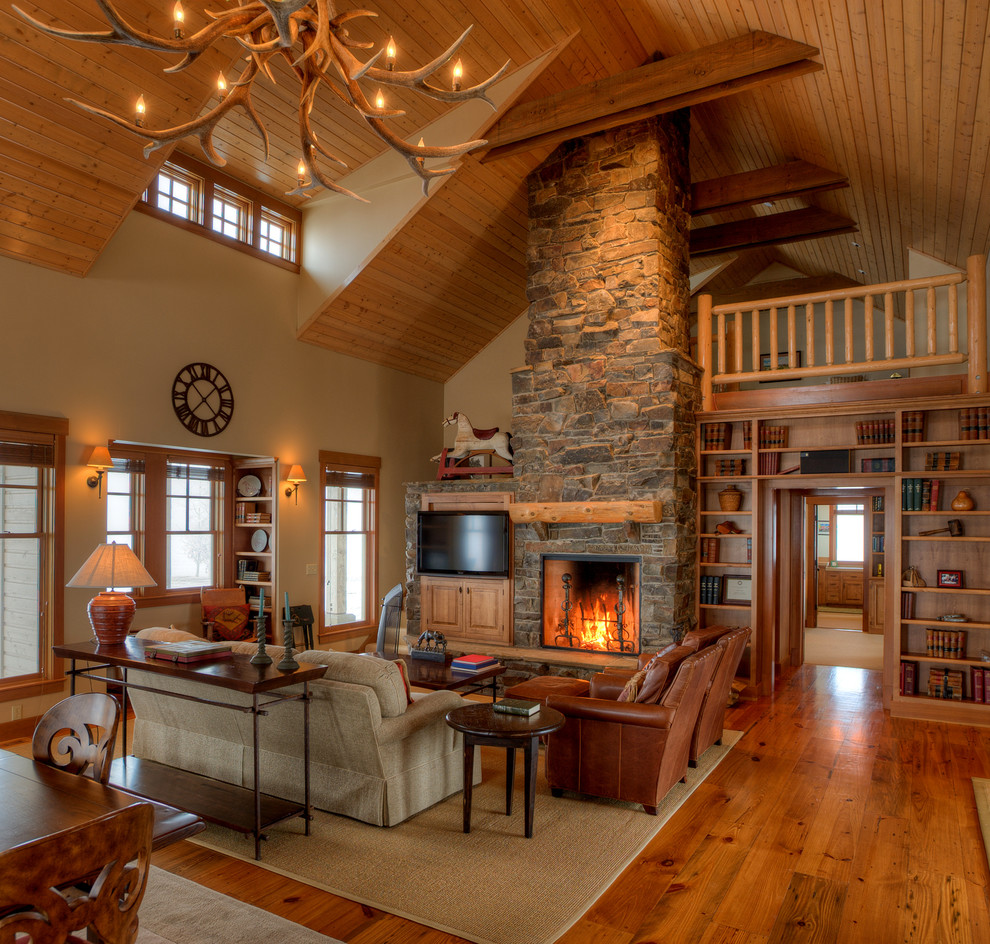 Mid-sized country open concept living room in Seattle with a standard fireplace, a stone fireplace surround, a built-in media wall, beige walls, medium hardwood floors and brown floor.