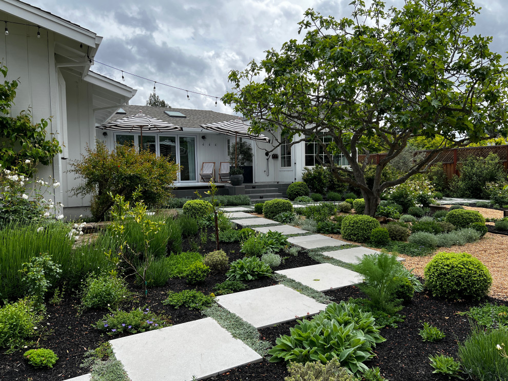 Пример оригинального дизайна: солнечный, летний участок и сад среднего размера на заднем дворе в стиле кантри с садовой дорожкой или калиткой, хорошей освещенностью, покрытием из гравия и с деревянным забором