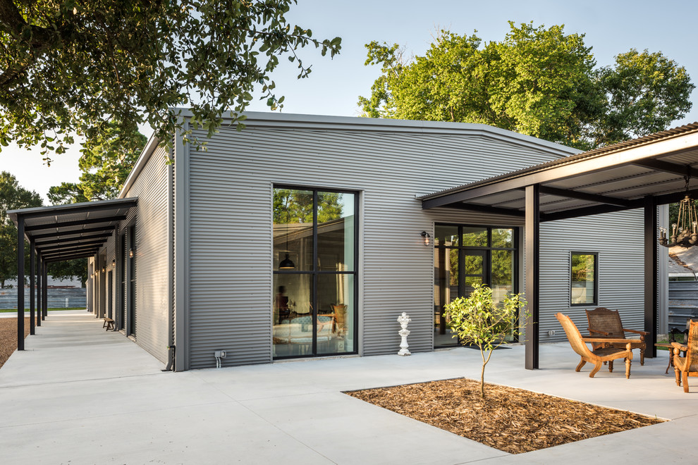 This is an example of a large industrial one-storey grey exterior in Houston with metal siding and a gable roof.