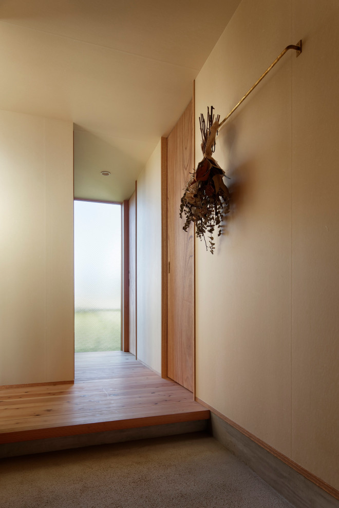 Immagine di un corridoio di medie dimensioni con pareti beige, pavimento in legno massello medio, una porta scorrevole, una porta in legno bruno, soffitto in carta da parati e carta da parati