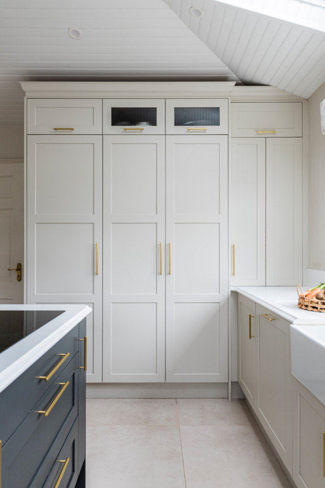 This is an example of a large contemporary u-shaped open plan kitchen in Other with a farmhouse sink, shaker cabinets, beige cabinets, granite benchtops, white splashback, granite splashback, black appliances, cement tiles, multiple islands, beige floor, white benchtop and vaulted.