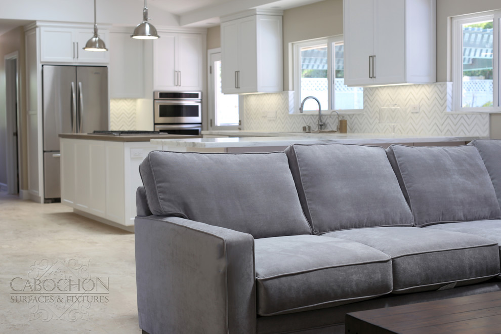 Inspiration for a mid-sized transitional l-shaped limestone floor open concept kitchen remodel in San Diego with an island, shaker cabinets, white cabinets, marble countertops, white backsplash, mosaic tile backsplash, stainless steel appliances, an undermount sink and beige walls