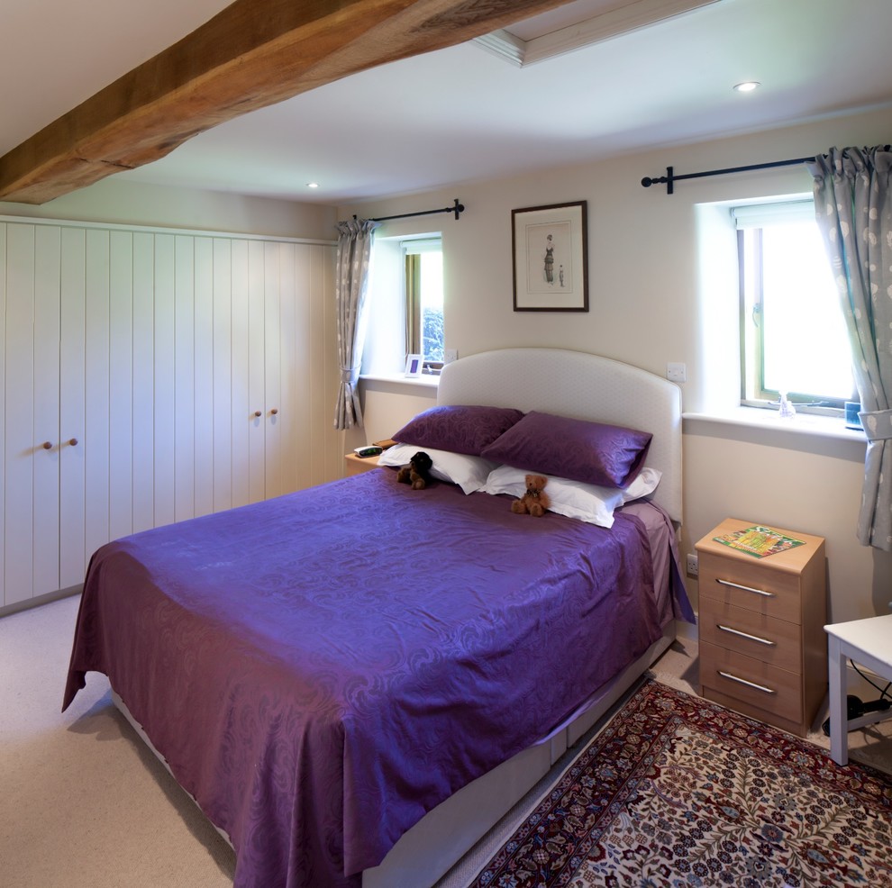 Country master bedroom in Gloucestershire with beige walls and carpet.