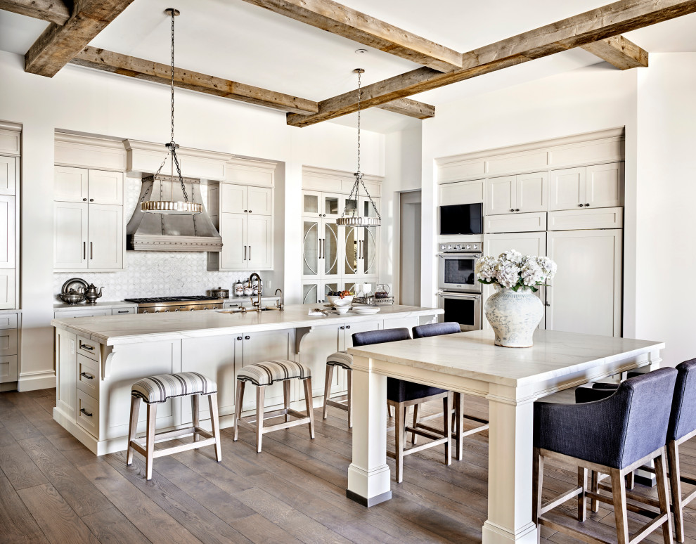 Inspiration for an expansive mediterranean kitchen in Phoenix with a submerged sink, raised-panel cabinets, white cabinets, white splashback, dark hardwood flooring, an island, white worktops and exposed beams.