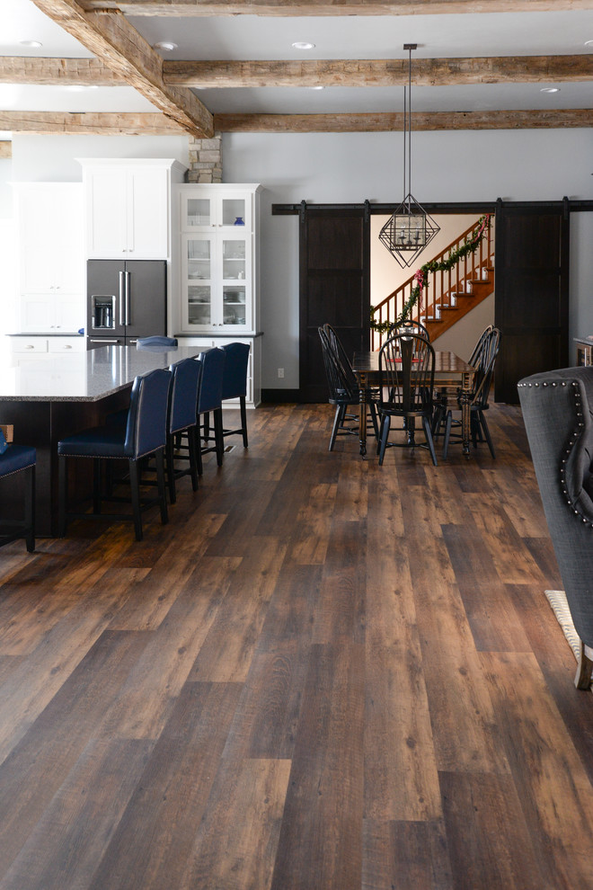 Example of a vinyl floor and brown floor kitchen design with recessed-panel cabinets, white cabinets and white backsplash