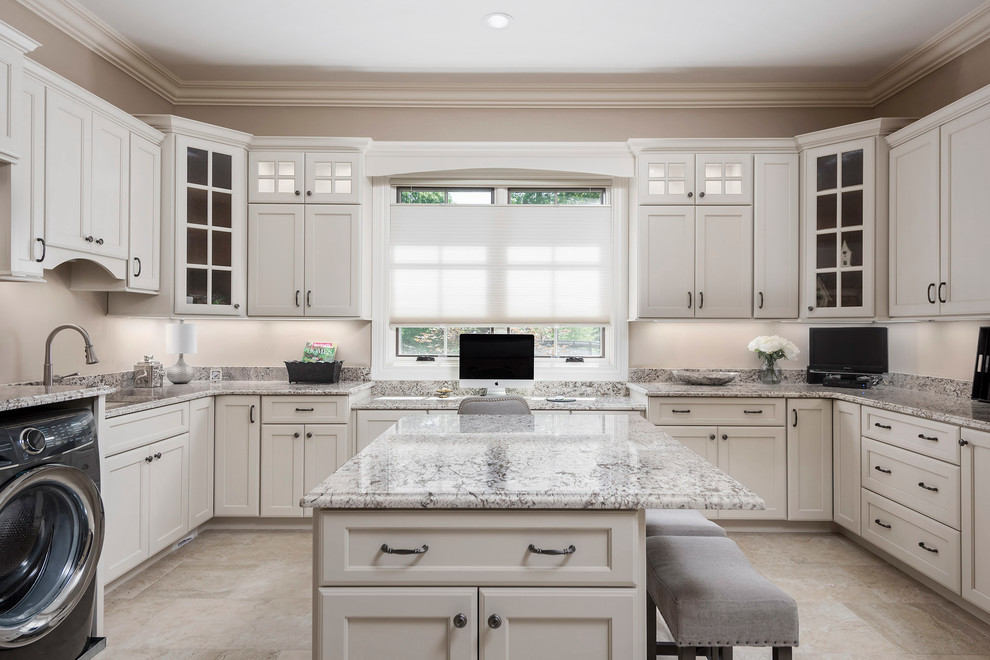 This is an example of a large traditional u-shaped utility room in St Louis with flat-panel cabinets, white cabinets, granite benchtops, a side-by-side washer and dryer and beige floor.
