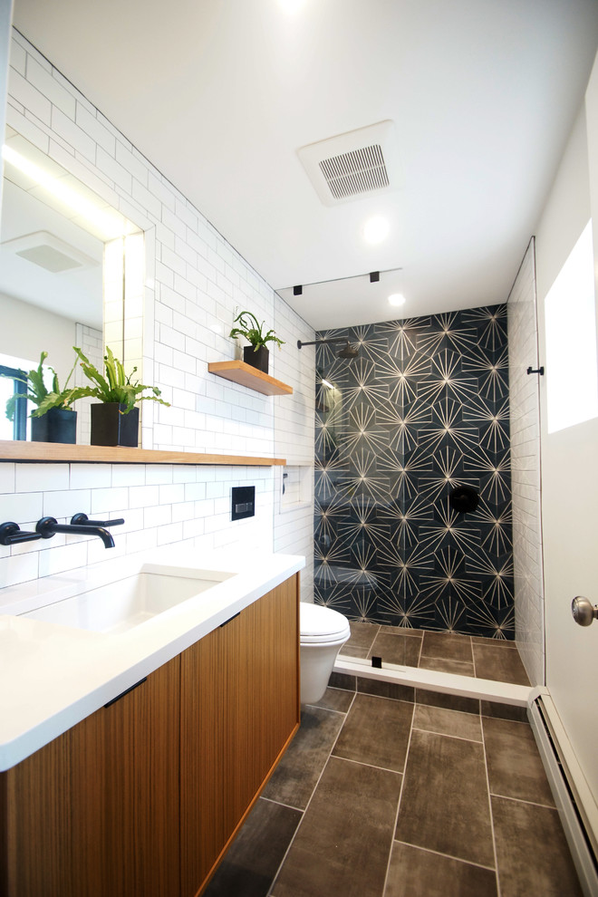 Design ideas for a small contemporary 3/4 wet room bathroom in Boston with flat-panel cabinets, medium wood cabinets, a one-piece toilet, white tile, subway tile, grey walls, porcelain floors, an undermount sink, engineered quartz benchtops, grey floor, a hinged shower door and white benchtops.