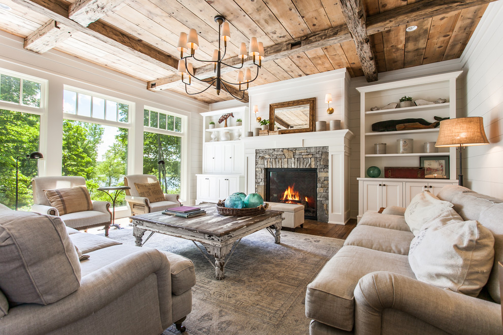 This is an example of a country formal open concept living room with white walls, medium hardwood floors, a standard fireplace, a stone fireplace surround, no tv and brown floor.