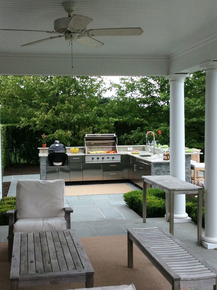 Photo of a large traditional backyard patio in New York with an outdoor kitchen, an awning and concrete pavers.