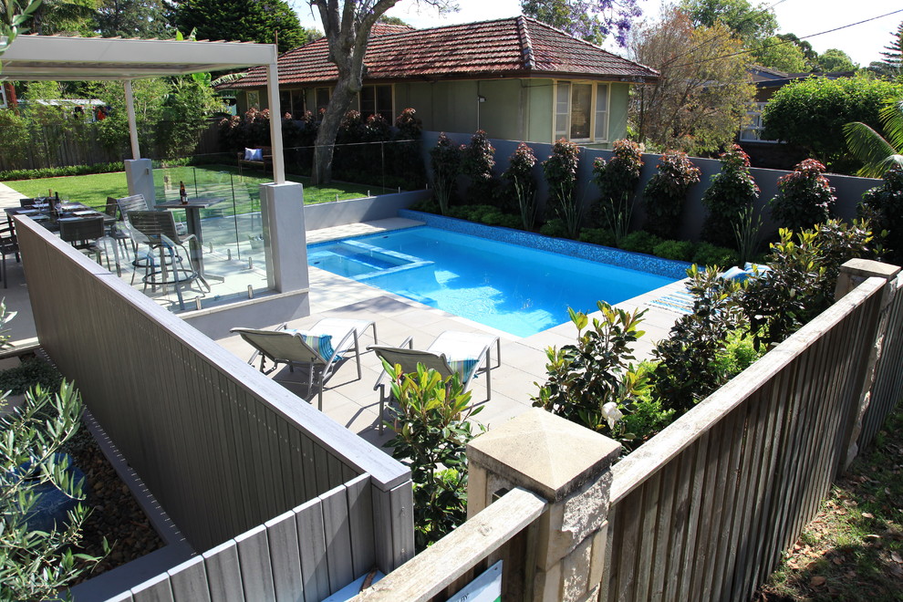 Photo of a mid-sized contemporary backyard rectangular lap pool in Sydney with a hot tub and concrete pavers.