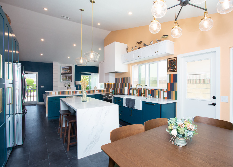 Inspiration for a mid-sized transitional l-shaped black floor open concept kitchen remodel in Orange County with a farmhouse sink, shaker cabinets, turquoise cabinets, multicolored backsplash, stainless steel appliances, an island, white countertops and quartz countertops