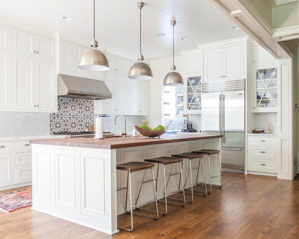Inspiration for a large transitional l-shaped kitchen in Charlotte with an undermount sink, recessed-panel cabinets, white cabinets, multi-coloured splashback, stainless steel appliances, dark hardwood floors, with island, wood benchtops and brown floor.