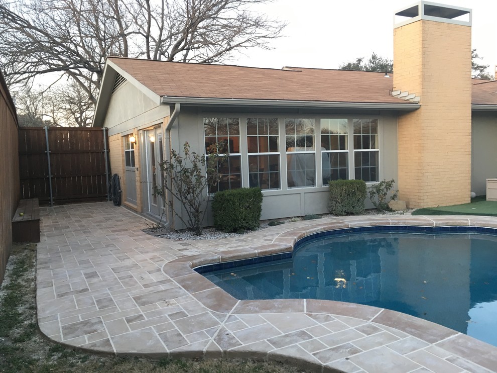 This is an example of a mid-sized contemporary backyard custom-shaped natural pool in Dallas with stamped concrete.
