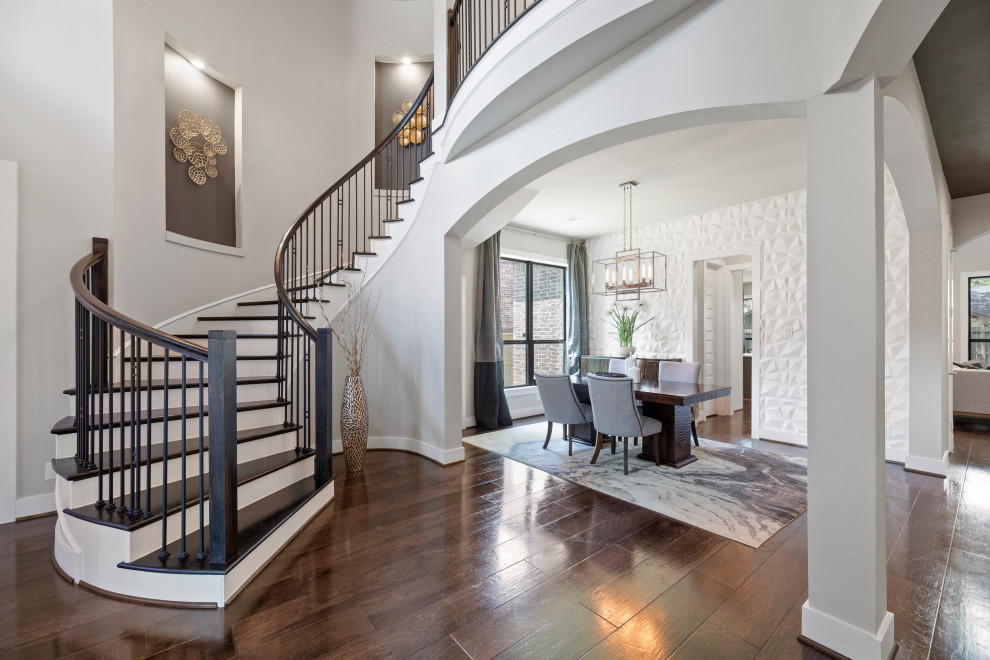 Photo of a large contemporary foyer in Houston with white walls, dark hardwood floors and panelled walls.