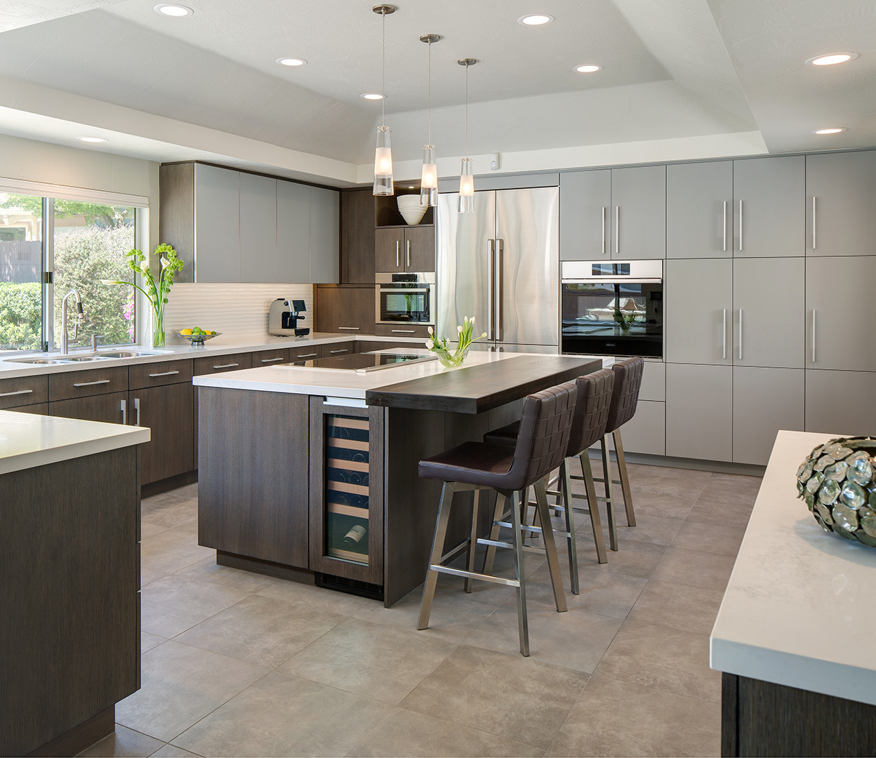 We chose a rich rift cut white oak cabinet door with custom glazing and a wire-brushed texture for the majority of the kitchen. To create more depth we used grey painted cabinets for the tall pantry a