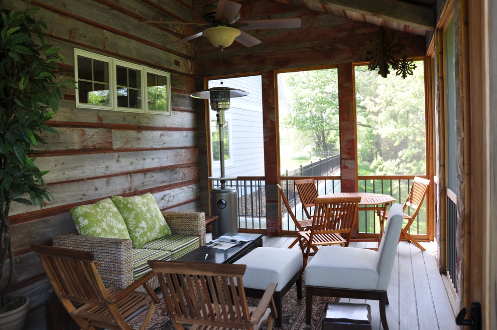 Design ideas for a mid-sized country backyard screened-in verandah in Minneapolis with decking and a roof extension.