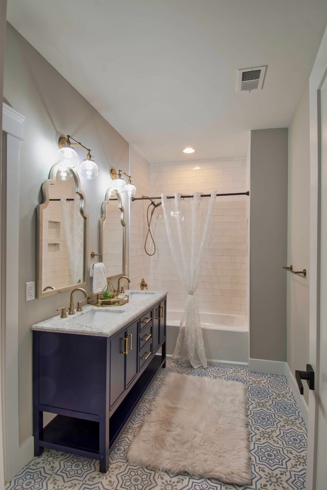 Transitional 3/4 bathroom in Charlotte with blue cabinets, an alcove tub, a shower/bathtub combo, grey walls, an undermount sink, multi-coloured floor, a shower curtain, white benchtops, recessed-panel cabinets and a freestanding vanity.