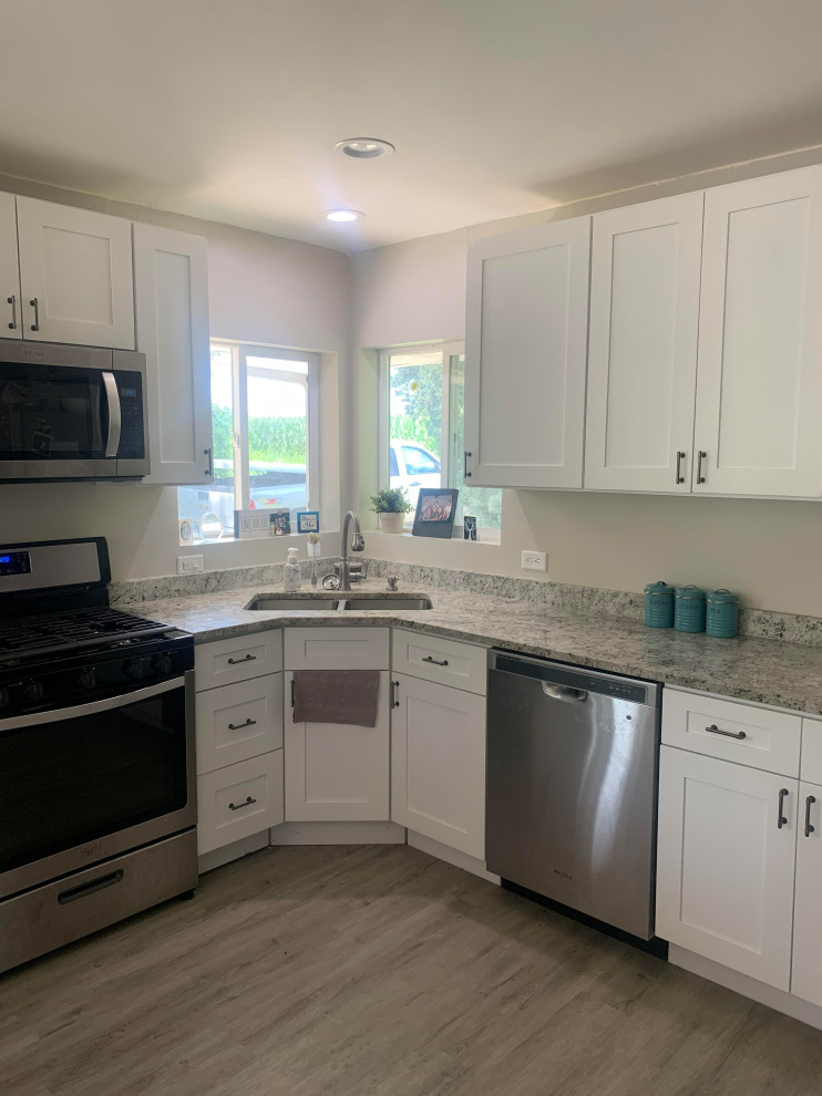 Example of a mid-sized transitional u-shaped vinyl floor and gray floor eat-in kitchen design in Chicago with a double-bowl sink, shaker cabinets, white cabinets, granite countertops, stainless steel appliances, an island and multicolored countertops