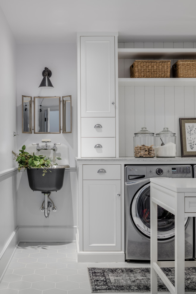 Photo of a beach style laundry room in Seattle with an utility sink, recessed-panel cabinets, white cabinets, shiplap splashback, white walls, a side-by-side washer and dryer, grey floor, grey benchtop and decorative wall panelling.