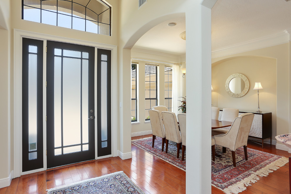 Inspiration for a mid-sized transitional front door in Tampa with beige walls, medium hardwood floors, a single front door and a glass front door.