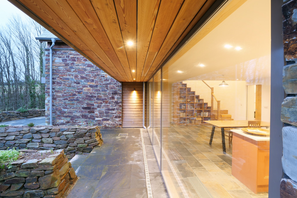 Aménagement d'une terrasse arrière contemporaine de taille moyenne avec des pavés en pierre naturelle.