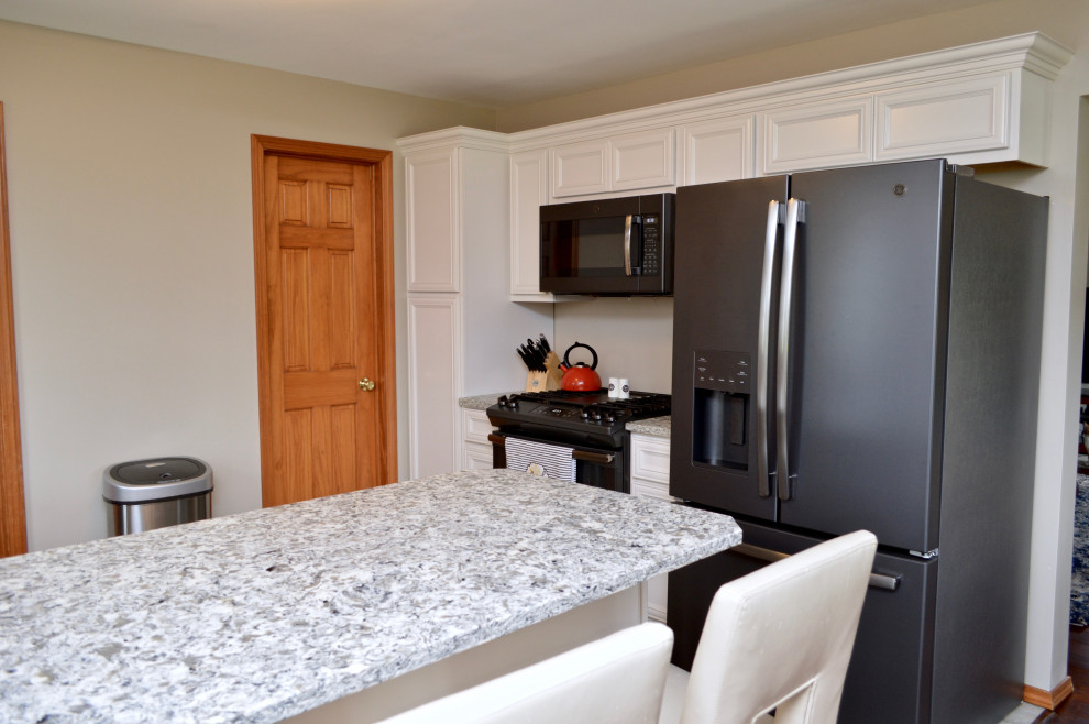 Example of a mid-sized transitional l-shaped eat-in kitchen design in Chicago with an undermount sink, recessed-panel cabinets, white cabinets, quartzite countertops, stainless steel appliances, a peninsula and gray countertops