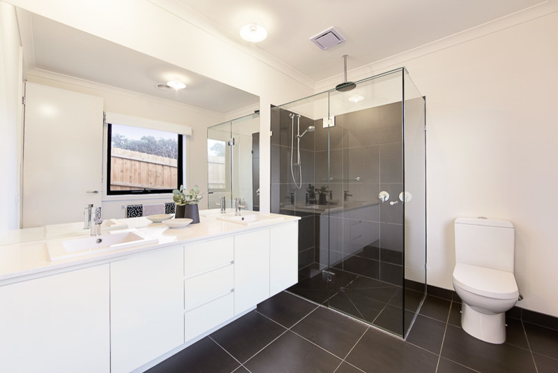 Design ideas for a mid-sized modern master bathroom in Melbourne with raised-panel cabinets, white cabinets, a corner shower, a one-piece toilet, black tile, ceramic tile, white walls, porcelain floors, a drop-in sink and marble benchtops.
