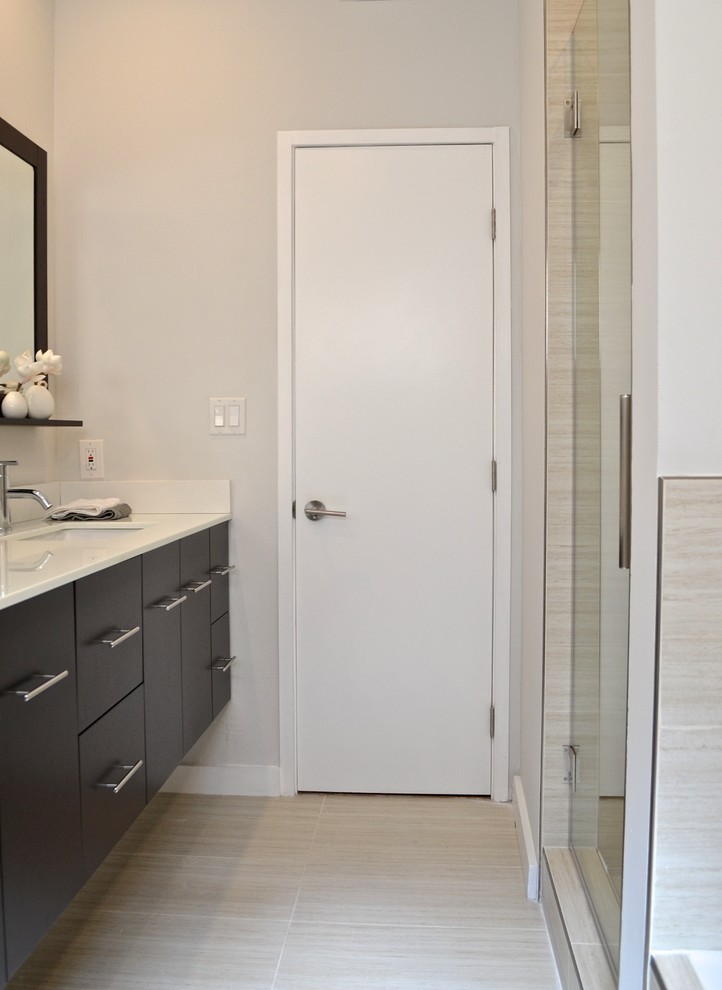 Design ideas for a small modern master bathroom in Los Angeles with an undermount sink, flat-panel cabinets, solid surface benchtops, a drop-in tub, an alcove shower, a one-piece toilet, beige tile, porcelain tile, white walls, porcelain floors and dark wood cabinets.
