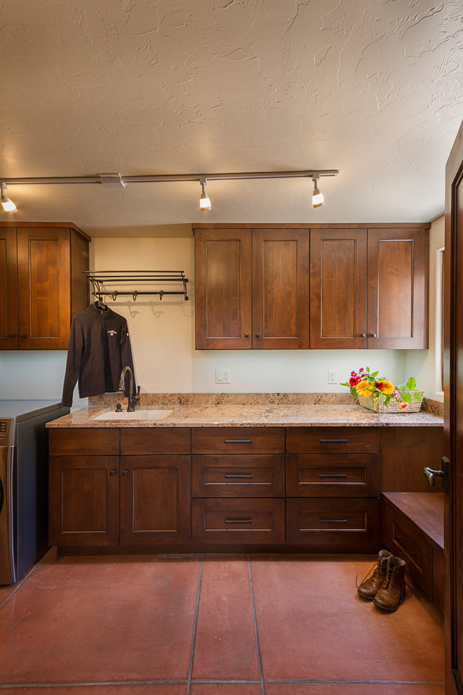 Design ideas for a single-wall dedicated laundry room in Phoenix with a drop-in sink, recessed-panel cabinets, granite benchtops, beige walls, ceramic floors, a side-by-side washer and dryer and dark wood cabinets.