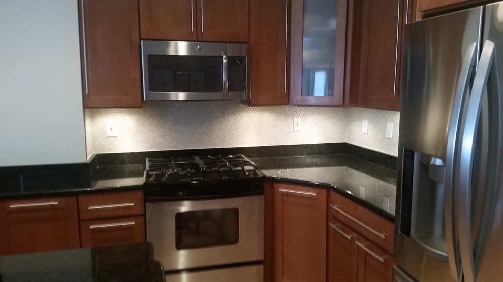 Enclosed kitchen - mid-sized transitional l-shaped enclosed kitchen idea in Baltimore with shaker cabinets, dark wood cabinets, quartz countertops, gray backsplash, mosaic tile backsplash, stainless steel appliances and an island