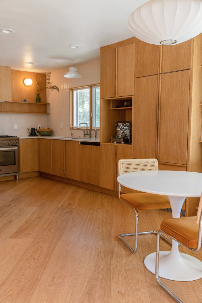 Mid-sized country u-shaped eat-in kitchen in Los Angeles with a drop-in sink, flat-panel cabinets, medium wood cabinets, marble benchtops, white splashback, ceramic splashback, coloured appliances, vinyl floors, a peninsula, beige floor, white benchtop and exposed beam.