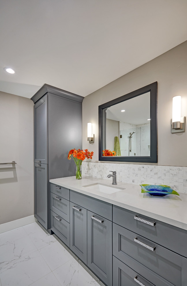 Example of a mid-sized transitional u-shaped white tile bathroom design in Sacramento with an undermount sink, recessed-panel cabinets, quartz countertops, white backsplash, porcelain backsplash, stainless steel appliances, an island, gray walls, gray cabinets and gray countertops