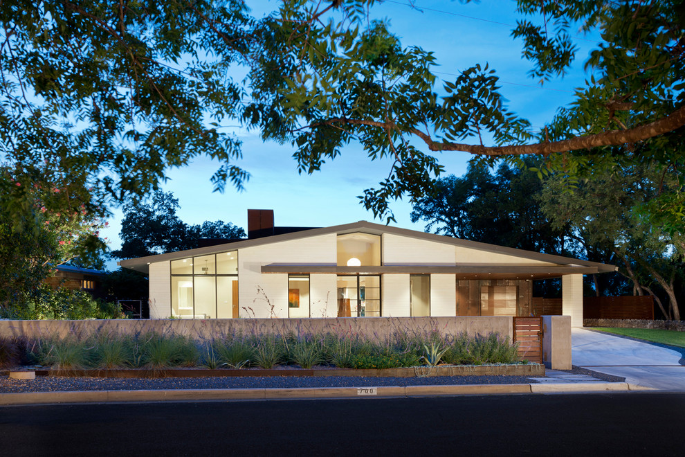 Photo of a midcentury one-storey exterior in Austin with a gable roof.